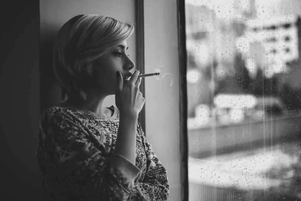 A lonely young girl smoking something.