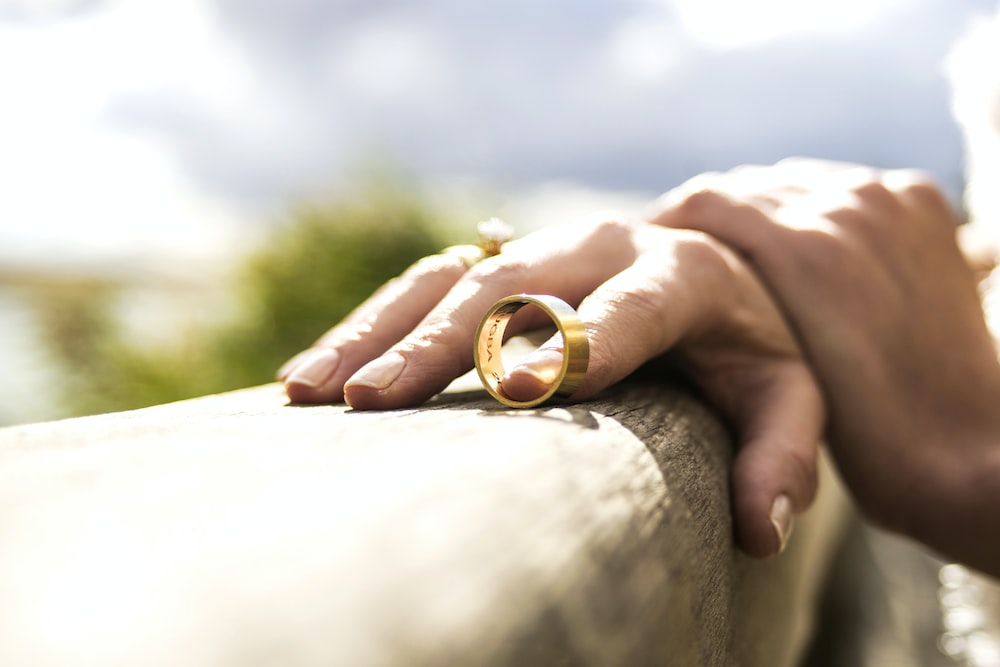 a person holding on to a wedding ring.